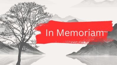 A black and white image of a tree on the edge of a mountain lake with a red manner that reads "In Memoriam"